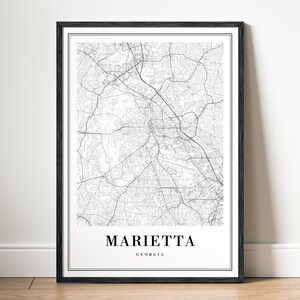 May include: Black and white map print of Marietta, Georgia in a black frame. The map shows the city streets and roads.