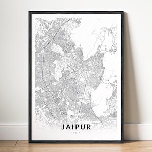 May include: A framed monochrome print featuring a detailed map of Jaipur, India. The map highlights the city's road network and urban structure. The city's name and country are printed in a simple font at the bottom of the print.