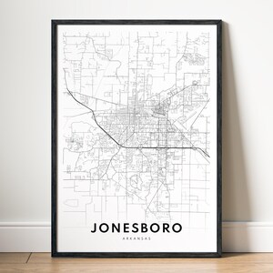 May include: A framed black and white map print of Jonesboro, Arkansas. The map shows the city's streets and infrastructure in a detailed, minimalist style. The city name and state are printed in a clean, sans-serif font at the bottom.