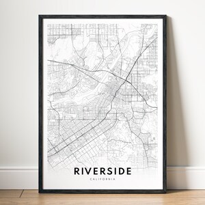May include: A black and white map print of Riverside, California. The map shows the city's streets and roads.