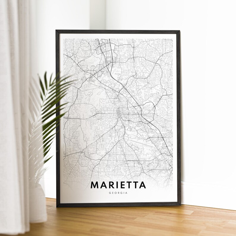 May include: Black and white map print of Marietta, Georgia in a black frame. The map shows the city streets and roads.