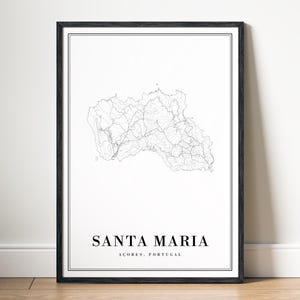 May include: A framed print with a black border, displaying a monochrome map of Santa Maria, Azores, Portugal. The map is a detailed line drawing. The text "SANTA MARIA" and "AÇORES, PORTUGAL" are printed in a clean, sans-serif font.