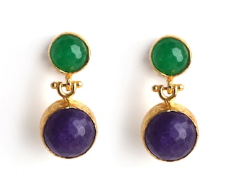 May include: Gold earrings with a green and purple stone. The earrings have a textured gold finish.