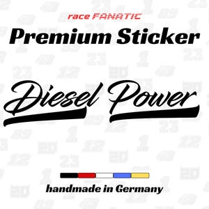 Op de afbeelding: Een witte sticker met de tekst "Premium Sticker" in een vetgedrukte, zwarte lettertype boven de woorden "Diesel Power" in een gestileerd schrift. De sticker bevat ook de tekst "handmade in Germany" en een kleuren balk.