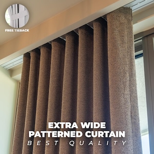 May include: A close-up of a brown, textured curtain with the text "EXTRA WIDE PATTERNED CURTAIN BEST QUALITY". The curtain is hanging from a track and has a "FREE TIEBACK" shown in the upper left corner.