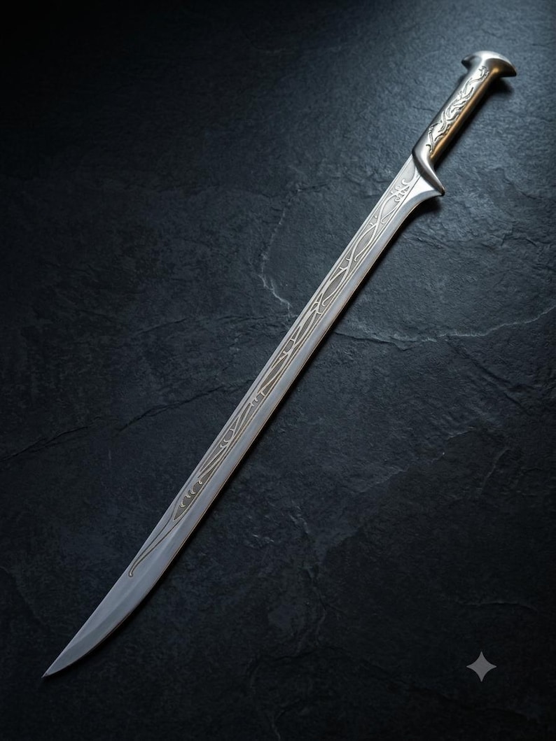 May include: A silver-toned sword featuring a curved blade with intricate, etched vine-like patterns running along the center. The hilt has a smooth, metallic finish with a flared pommel, and the design extends from the guard down the blade.