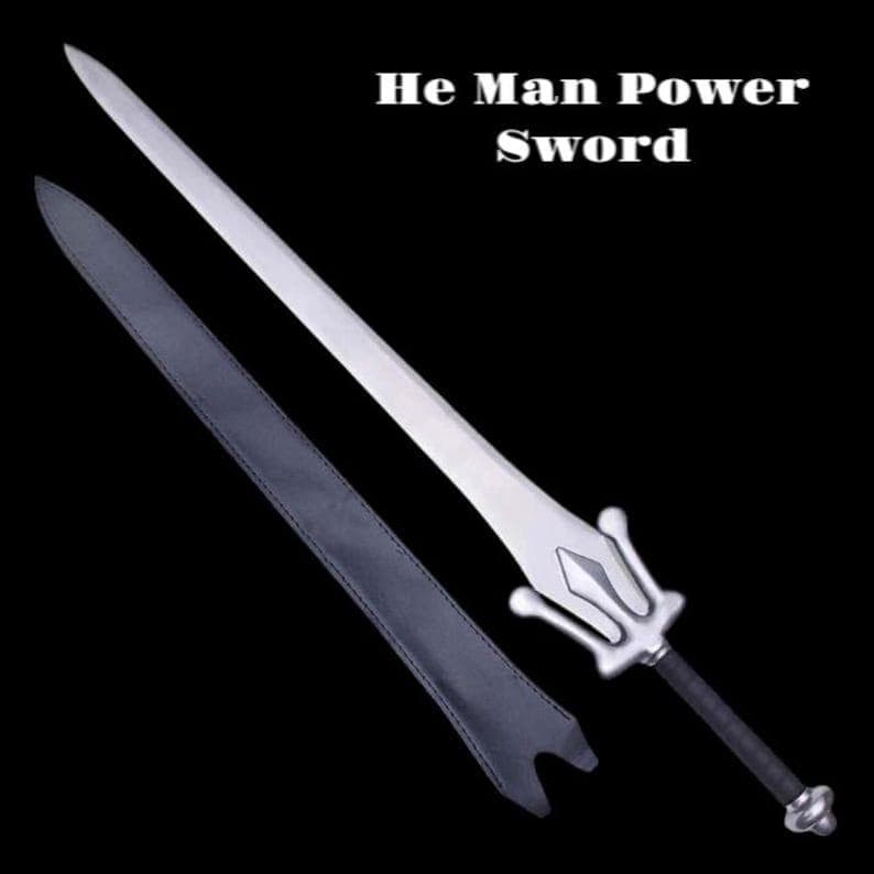 Op de afbeelding: Een zilverkleurig zwaard met een opvallende stootplaat en een zwart handvat, vergezeld van een zwarte schede. De tekst 'He Man Power Sword' wordt in witte letters boven het zwaard weergegeven tegen een zwarte achtergrond.