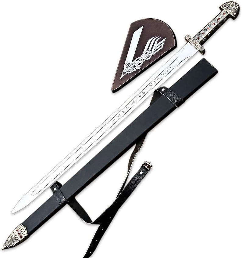 May include: A silver-toned metal sword featuring a long blade with etched runic characters, a detailed hilt with red accents, and a black scabbard with a matching silver-toned tip. A triangular brown leather patch with a white graphic is included.