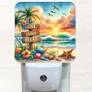 May include: A night light with a colorful beach scene and a wooden sign that reads "Live Laugh Relax". The scene includes palm trees, ocean waves, and seashells.
