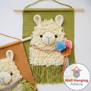 May include: Crochet wall hanging with a llama design. The llama has cream-coloured, textured fur, black eyes, and a white face. It is decorated with colourful pom-poms and a tassel. The background is olive green with a fringe at the bottom. A second, smaller wall hanging is also visible.