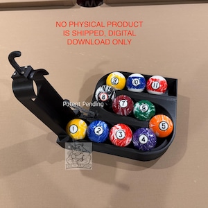 May include: Black 3D-printed billiard ball rack holding numbered billiard balls. The rack is open, displaying the balls in a semi-circle. The text "Patent Pending" and "RHINOMANSHOP" are visible.