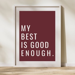 Może przedstawiać: Wydruk w ramie z bordowym tłem i białym tekstem, kt&oacute;ry brzmi "MY BEST IS GOOD ENOUGH."
