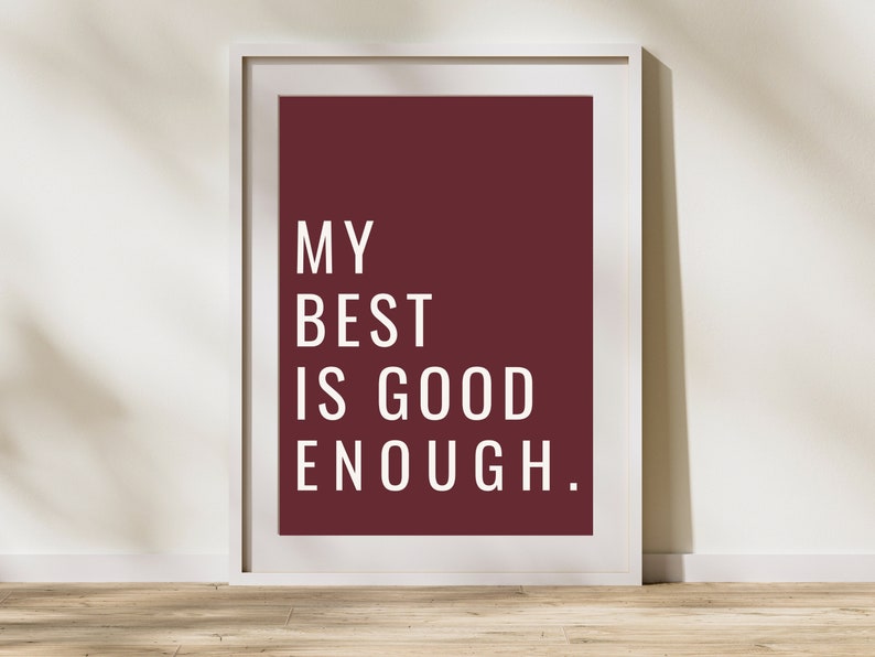 Może przedstawiać: Wydruk w ramie z bordowym tłem i białym tekstem, kt&oacute;ry brzmi "MY BEST IS GOOD ENOUGH."