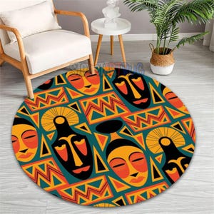Pode incluir: Um tapete redondo com um design vibrante de máscaras tribais africanas. O tapete apresenta padrões repetidos de máscaras laranja, amarelas e pretas sobre um fundo turquesa. Formas e linhas geométricas completam o design.