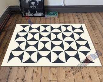 May include: A rectangular rug with a geometric pattern. The rug features a cream-colored background with a repeating pattern of navy blue shapes. The shapes are arranged in a symmetrical design, creating a modern and stylish look.