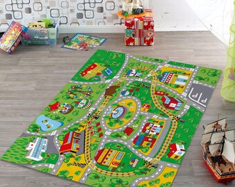 May include: A rectangular green play rug with a city and road design. The rug features roads, buildings, a ferris wheel, and a pond. The rug is on a wooden floor. A toy ship is on the floor near the rug.