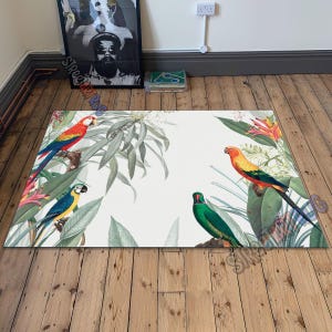 May include: Rectangular rug featuring a tropical design with colorful parrots perched among lush green foliage and flowers. The rug has a white background and the text "STREET ART RUG" is visible in the corner.
