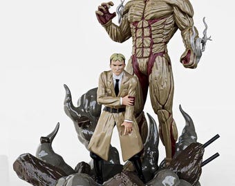 May include: A detailed figurine featuring two characters from "Attack on Titan." One is a large, muscular titan with exposed muscle and red accents. The other is a man in a tan coat. The base has the Japanese title and English subtitle.