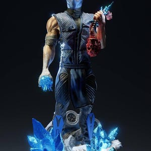 Puede incluir: Estatua detallada de un personaje enmascarado con un atuendo azul y negro, sosteniendo un objeto sangriento y una bola de energía azul. La figura se encuentra sobre una base con formaciones de cristal azul. Fondo oscuro.