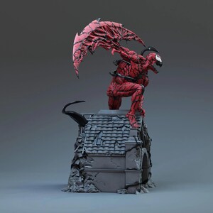 May include: A red and black statue of a comic book character, posed on a rooftop. The figure has a detailed, textured appearance with a large, wing-like structure extending from its back. The rooftop is gray and weathered.