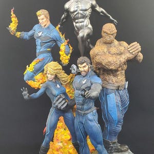 Op de afbeelding: Een gedetailleerde beeldjesset met de Fantastic Four en Silver Surfer. De figuren staan in dynamische poses, met levendige kleuren en texturen. De Human Torch is omringd door vlammen, terwijl The Thing een rotsachtig uiterlijk heeft. Silver Surfer is metaalachtig.