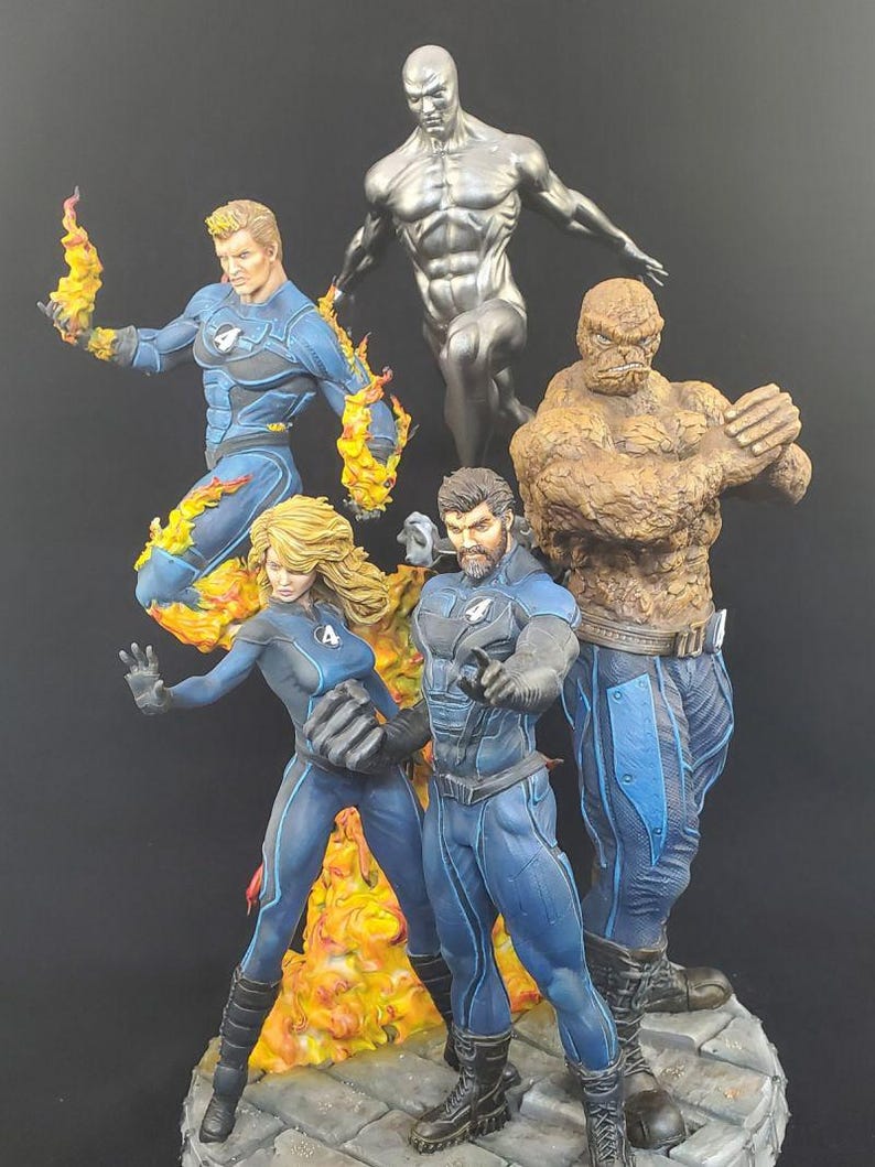 Op de afbeelding: Een gedetailleerde beeldjesset met de Fantastic Four en Silver Surfer. De figuren staan in dynamische poses, met levendige kleuren en texturen. De Human Torch is omringd door vlammen, terwijl The Thing een rotsachtig uiterlijk heeft. Silver Surfer is metaalachtig.