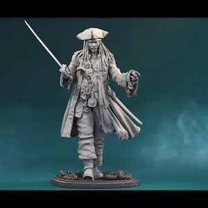 Op de afbeelding: Een gedetailleerd grijs beeldje van een piraat, met een zwaard en een pistool. De piraat draagt een driekantige hoed, lange jas en heeft dreadlocks. Het beeldje staat op een cirkelvormige basis met touwdetails, tegen een blauwgroene achtergrond.