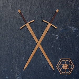 Puede incluir: Dos espadas de madera cruzadas en forma de X sobre un fondo azul oscuro. Las espadas tienen mangos marrones y están hechas de madera clara.