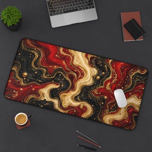 May include: A rectangular desk mat featuring a fluid, marbled pattern of deep red, black, and metallic gold swirls. The design includes scattered gold-coloured spheres and fine glitter accents across the surface, creating a dynamic, flowing visual effect.