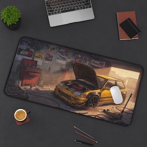 Può includere: Un tappetino da scrivania rettangolare con un'illustrazione dettagliata di un'auto hatchback gialla con il cofano aperto all'interno di un garage disordinato. La scena include una cassetta degli attrezzi rossa, vari strumenti e poster con testo giapponese.