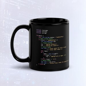 Puede incluir: Una taza de cerámica negra con código de programación C++ impreso en texto blanco, azul y verde. El código incluye líneas como #include <iostream>, const std::string status = "needsCoffee"; e instrucciones para preparar café con leche o azúcar.