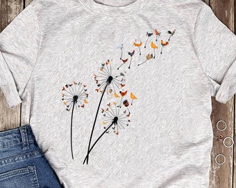 May include: A gray t-shirt with a design of two dandelion flowers with colorful chickens flying away from them.