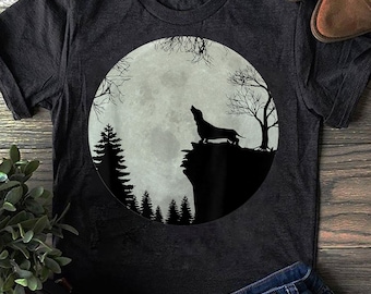 May include: A black t-shirt with a silhouette of a dachshund howling at the moon in a forest setting.