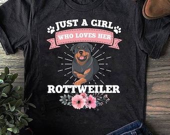 May include: Black t-shirt with a pink and white floral design and the text "Just a girl who loves her Rottweiler".
