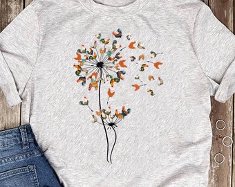 May include: A gray t-shirt with a black and white graphic of a dandelion made of roosters. The roosters are various colors, including orange, red, yellow, and blue.