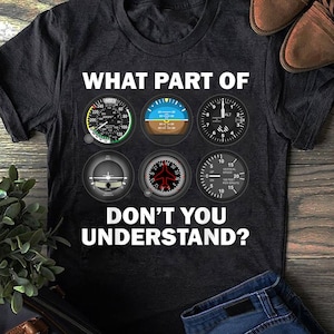 May include: A black t-shirt with a white graphic of aircraft instrument panels and the text "WHAT PART OF DON'T YOU UNDERSTAND?"