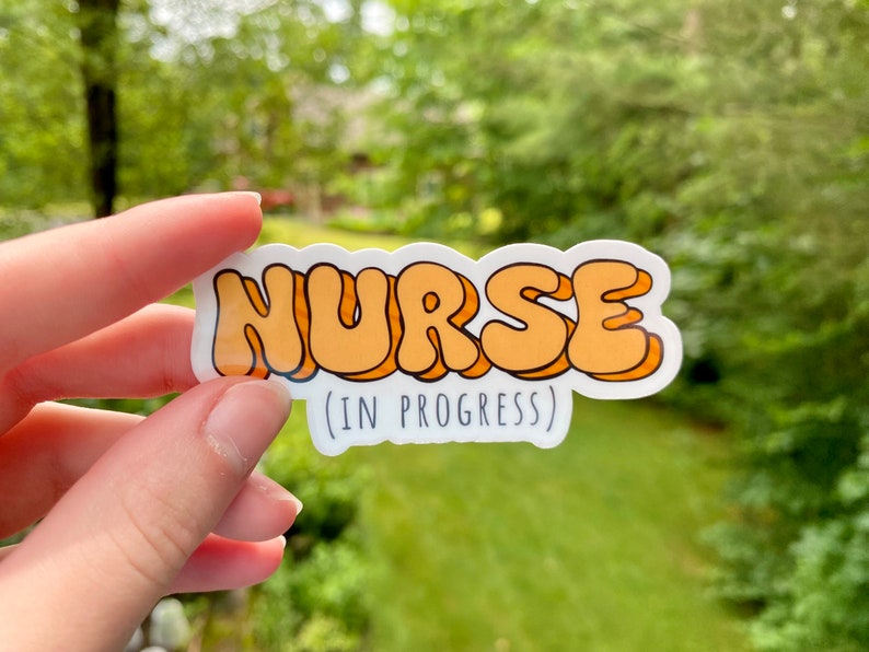 May include: A white sticker with the word "NURSE" in orange bubble letters and the text "(IN PROGRESS)" below.