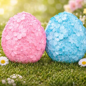 以下が含まれることがあります： ピンクとブルーの2つの装飾的なイースターエッグは、花柄で覆われています。小さな白い花が咲く緑の草の上にあります。シーンは柔らかな日光に照らされ、陽気な春の雰囲気を醸し出しています。