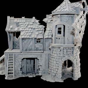 May include: A detailed gray miniature of a weathered windmill and building. The model features a stone tower, wooden doors, and a sloped roof with missing tiles. A ladder leads to a second-story balcony.