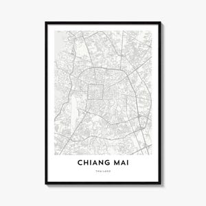 May include: A framed wall art print featuring a detailed grey and white street map of Chiang Mai, Thailand. The map displays a complex network of roads and city blocks. Below the map, the text reads CHIANG MAI in bold and THAILAND in smaller font.