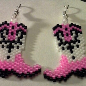 Peut inclure: Une paire de boucles d'oreilles en perles roses et noires en forme de bottes de cow-boy. Les boucles d'oreilles sont faites de petites perles et ont des crochets argentés.
