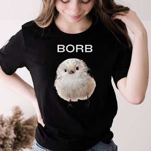 May include: Black t-shirt with a white bird graphic and the word "BORB" printed in white on the front.