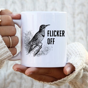 May include: White ceramic mug with a black and white illustration of a bird and the text "Flicker Off".