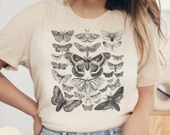 May include: A beige t-shirt with a black and white vintage illustration of various butterflies and moths. The illustration features a variety of species, including a large, prominent moth with feathery antennae.