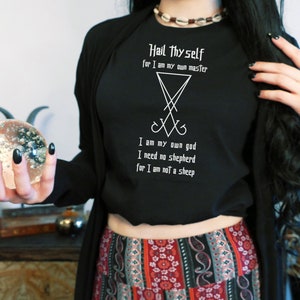 Puede incluir: Camiseta negra de manga larga con texto blanco que dice "Hail Thyself for I am my own master" y un s&iacute;mbolo de pentagrama. El texto contin&uacute;a con "I am my own god I need no shepherd for I am not a sheep."