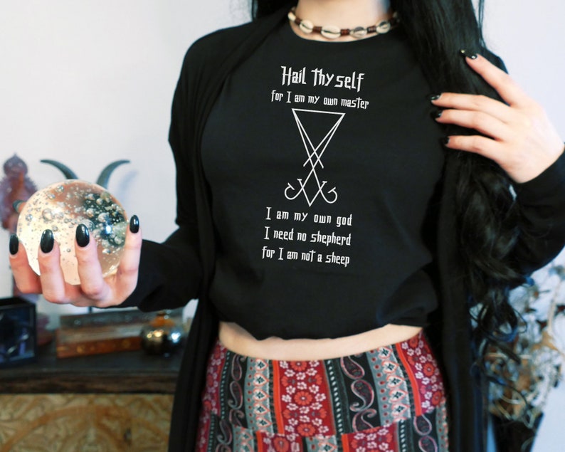 Puede incluir: Camiseta negra de manga larga con texto blanco que dice "Hail Thyself for I am my own master" y un s&iacute;mbolo de pentagrama. El texto contin&uacute;a con "I am my own god I need no shepherd for I am not a sheep."