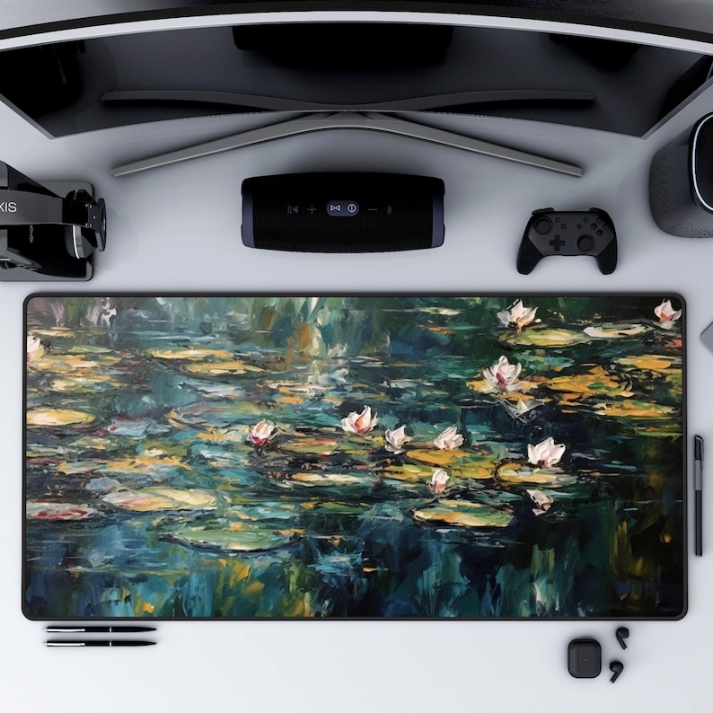 May include: A large, rectangular mousepad with a painting of water lilies on a pond. The painting is done in a style reminiscent of Impressionism, with loose brushstrokes and vibrant colors. The water lilies are white and pink, and the pond is a deep blue-green.