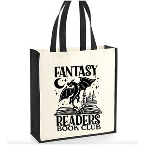 May include: A white canvas tote bag with black handles and black text that reads "Fantasy Readers Book Club". A black silhouette of a dragon flying over an open book with a castle and a crescent moon is in the center of the bag.