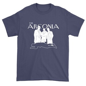 Puede incluir: Una camiseta azul marino con un gr&aacute;fico blanco de tres figuras y el texto "THE ARCONIA".
