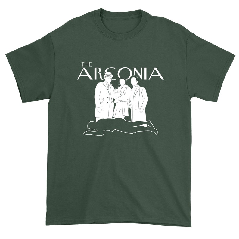 Puede incluir: Una camiseta verde oscuro con un gr&aacute;fico blanco de tres personas de pie frente al texto "THE ARCONIA".
